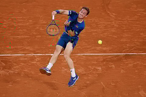 Roberto Carballes Baena serves against Novak Djokovic